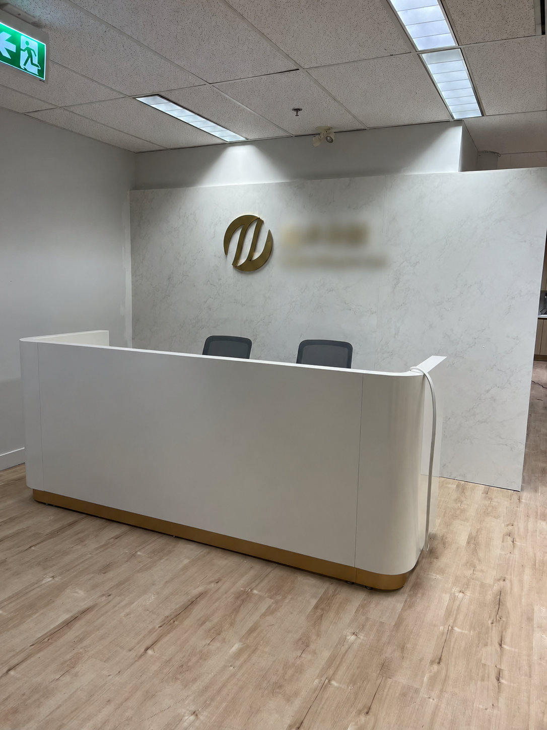 White reception desk with feature wall